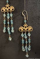 Full earrings showcasing the antique brass chandelier findings with blue crystal and bead dangles on gold plated ear wires