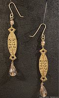 Full view of pair of antique brass dangle earrings with glass and crystal beads on gold plated ear wires