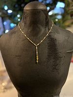 Full view of antique enamel chain necklace on black mannequin bust showing the chain detail and pendant at center front.