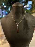 Full view of the antique enamel chain necklace displayed on a black mannequin bust showing chain and pendant layout