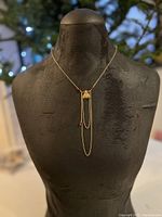 Full necklace displayed on black bust showing pendant and chain drape