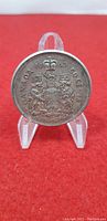 Front side of the 1963 Canadian 50 Cent silver coin showing the royal coat of arms and inscriptions.