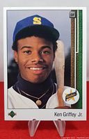 Front view of 1989 Upper Deck Ken Griffey Jr. rookie card with clear image of player's face, Seattle Mariners hat, and baseball bat.
