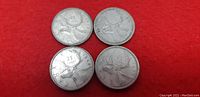 Reverse side of group of four Canadian quarters featuring caribou and denomination 25 cents