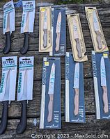 Photo of eleven boxed kitchen cutlery knives on a wooden surface, showing two distinct brands and packaging styles.