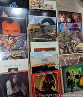 Photo showing a stack of vintage vinyl records with visible titles including Jeff Beck, Al Stewart, Glenn Frey, Hall & Oates, Nilsson, Randy Newman, Culture Club, Rod Stewart, Dan Fogelberg, and others.