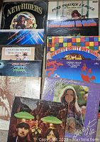 Photo of multiple vinyl record album covers stacked in two columns. Visible titles and artists include New Riders, Pure Prairie League, Mott the Hoople, Uriah Heep, Bonnie Raitt, and Seals & Crofts among others.