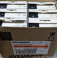 Box containing six packages of Sylvania LED 40W replacement light bulbs with candelabra bases, new in packaging.