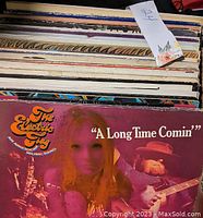 Top view of stack of vinyl records showing spine titles including The Electric Flag album 'A Long Time Comin'