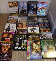 Photo showing 20 DVD movie cases arranged, featuring titles such as Titanic, The Polar Express, Big Fish, and others with clear front cover artwork visible.