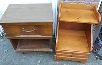 Two wooden end tables side by side with visible wear, drawer handles, and shelves.