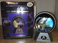 Photo of Star Trek The Next Generation special commemorative model box and model display showing U.S.S. Enterprise inside a clear sphere on graphic base