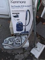 Kenmore Pet Friendly POP-N-GO bagged canister vacuum with hose, wand, and attached cleaning head shown outdoors
