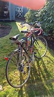Two bicycles, a black Schwinn at the front with a rear rack and another bike behind it.