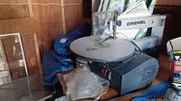 Full side view of Dremel 16in scroll saw showing worktable, blade guard, power base and power cord.