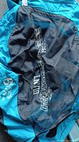 Close-up of black mesh bag labeled Giant Loop Bags inside blue inflatable raft