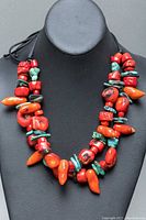 Front view of the necklace displayed on black bust showing the double strands with coral and turquoise beads.