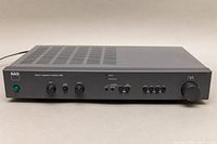 Front angle view of the NAD 310 stereo integrated amplifier showing controls and vents on the top.