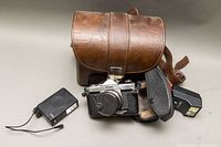 Overview photo showing Kowa Set R2 camera with attached lens, two separate flash units, leather carrying case, and camera carrying holster.