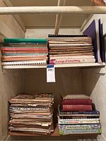 Large stacks of vintage sheet music and music books on a shelf showing colorful spines and titles.
