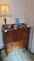 Full view of oak sideboard with decorative hardware and top contents