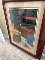 Angled view of pastel artwork showing stacked shaker boxes in various colors, framed in wood with matting.