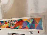Front view of the colorful rectangular wall art with abstract geometric patterns and a bird illustration.