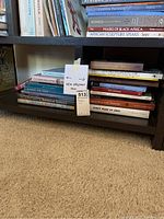 Books stacked on two shelves showing titles focused on New Orleans history, architecture, and culture along with African art and American Indians.