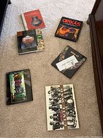 Seven assorted coffee table books arranged on carpet and table