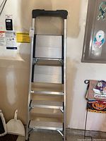 Front view of Gorilla aluminum A-frame ladder with safety step treads and black top cap.