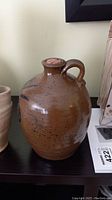 Stoneware jug front view showing body and handle attachment.