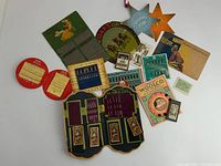 Overview photo of all items spread on flat surface, including needle books, hooks and eyes, ephemera, and original packaging.
