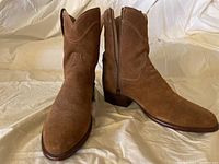 Front angle view of the brown suede Tecovas boots showing toe shape and side zipper detail.