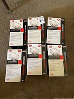 Six unopened boxes of SAS N95 valved particulate respirator masks, 10 masks per box, arranged on carpeted floor.