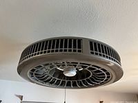Black Purifan ceiling fan mounted on ceiling showing side and bottom view.