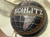 Close-up top view showing the globe design and 'SCHLITZ' lettering in stained glass.