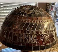 Close-up of the half globe stained glass light showing Schlitz branding and decorative mosaic glass pattern.