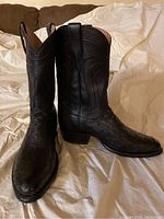 Pair of black Tecovas cowboy boots with pointed toe and textured exotic leather.