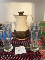 Vintage thermos with four diamond print drinking glasses arranged around it