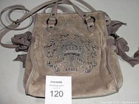 Front view of the Juicy Couture Royal velour purse laid flat showing the entire bag including handles and side ties