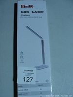 Box showing brand HimiGO, model HM01, aluminum alloy LED desk lamp with 5V 1A power rating and sealed condition.