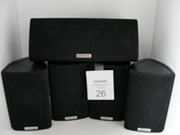 Five Polk Audio RM series speakers arranged with the center channel on top and four satellites below. Speakers have black fabric covering and visible Polk Audio logos.