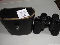 Binoculars with carrying case, showing overall condition and lot contents