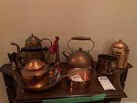 Photo of copper cookware including kettle, pot, pan, serving tray, and container
