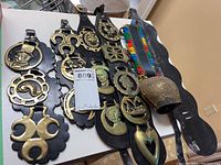 Complete view of all horse brasses and leather straps with bell and colorful strap