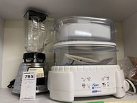 Photo of both Oster mixer and Oster instant steam food steamer side by side in a box