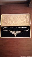 Full view of the vintage necklace displayed in an open box with tissue paper.