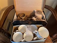 Set of 6 white Sadler tea cups, 2 teapots, and small cups in boxes on chair