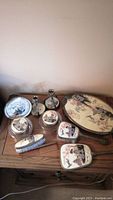 View of the full vanity set on a wooden table showing all 10 pieces including brushes, comb, mirror, clock, candlesticks, tray, and dishes with Japanese theme.