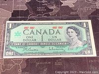 Front side of the 1967 Canadian Centennial one dollar banknote showing Queen Elizabeth II portrait and serial numbers 1867-1967.